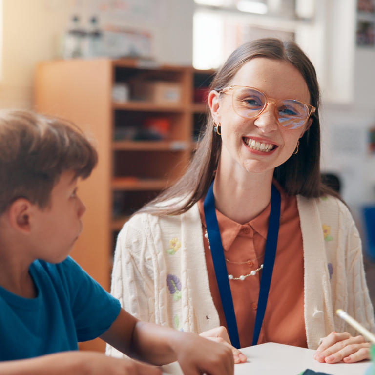 Teacher supporting a pupil in the classroom through inclusive learning and personalised support.
