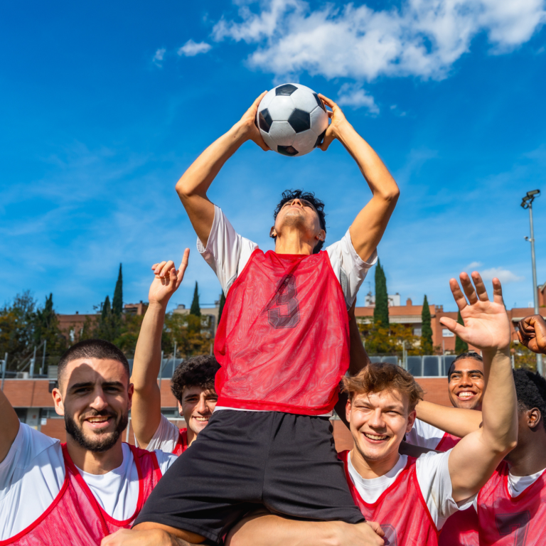 Young people celebrating together during a football session, promoting inclusion, teamwork and belonging.
