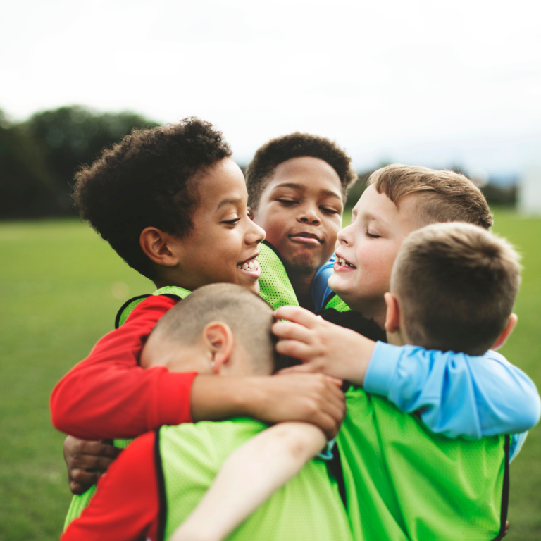 Children celebrating together during a school sports session, promoting inclusion, friendship and belonging.