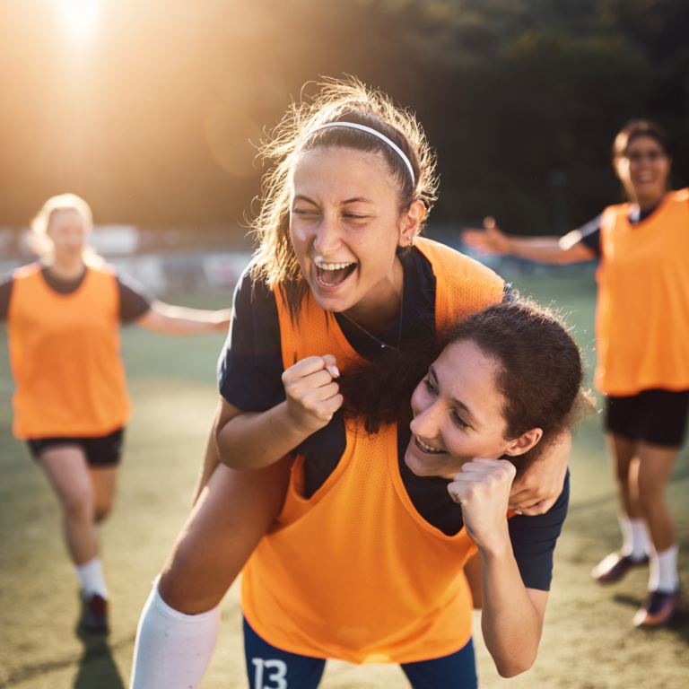 Young people celebrating together after a school sports activity, demonstrating inclusive participation and teamwork.