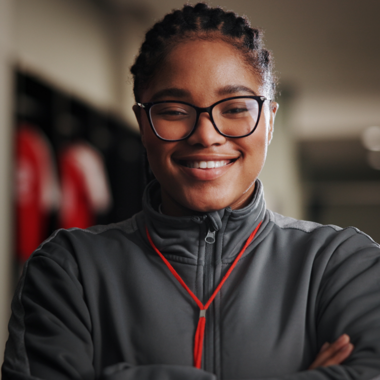 Confident young person smiling in a sports setting, representing inclusion, confidence and positive participation.
